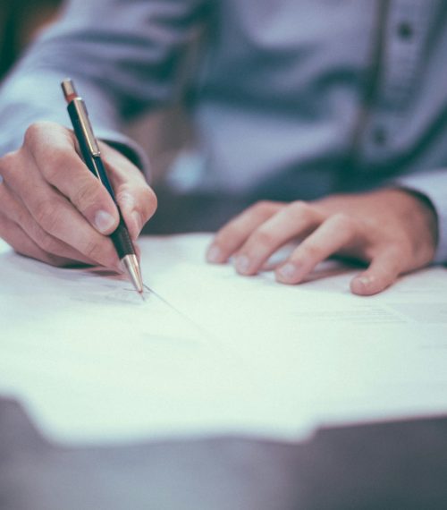 man writing on paper